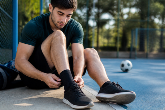 Deportista ajustando una tobillera antes de volver a jugar después de un esguince