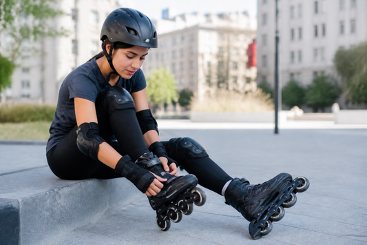 Persona ajustando sus patines en línea antes de salir a patinar con protecciones