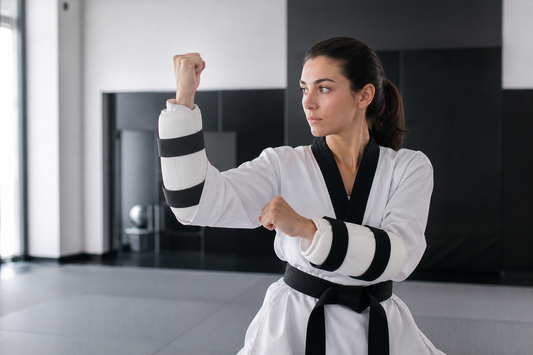 Practicante de taekwondo usando antebraceras durante un ejercicio de bloqueo