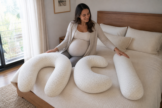 Mujer comparando formas y tamaños de cojines para embarazada junto a su cama