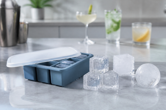Cubetera de silicona junto a hielos de distintos tamaños y formas