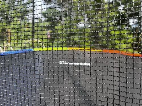 Vista superior de trampolín con lona negra y borde multicolor